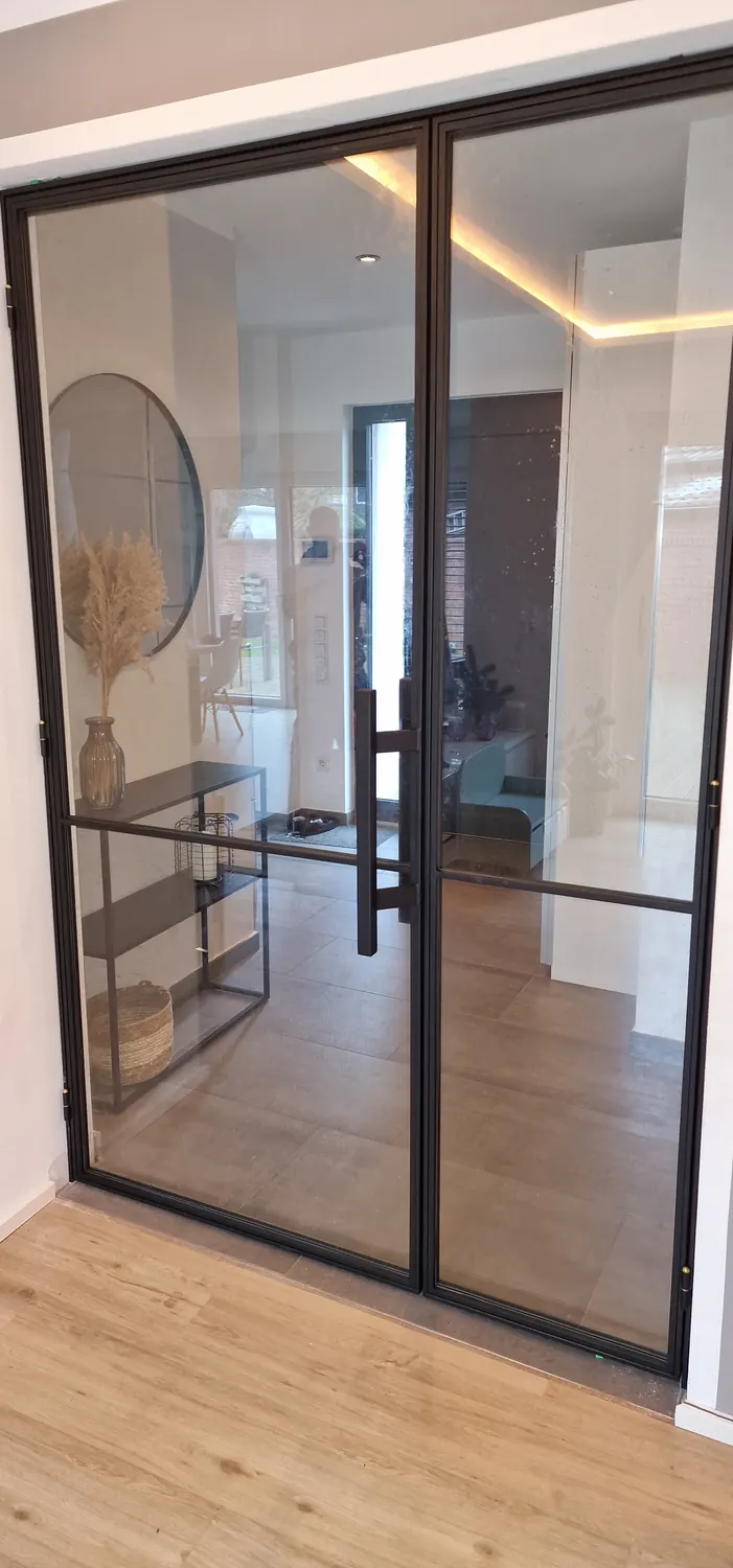Doppeltür aus Stahl und Glas mit Stangengriffen im Flur
