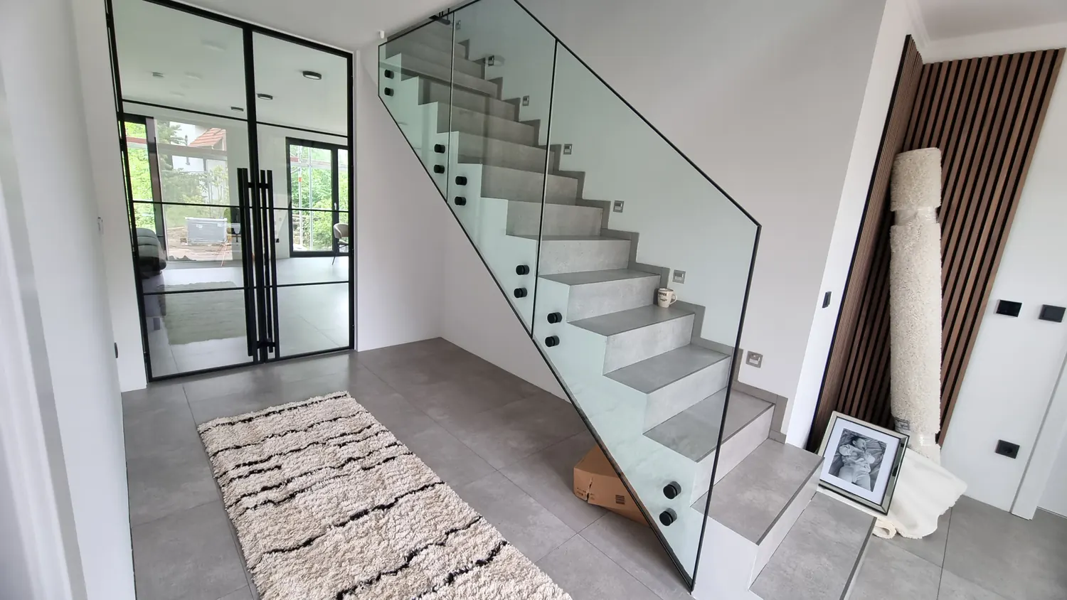 Ganzglas-Geländer an einer Betontreppe neben einer Lofttür