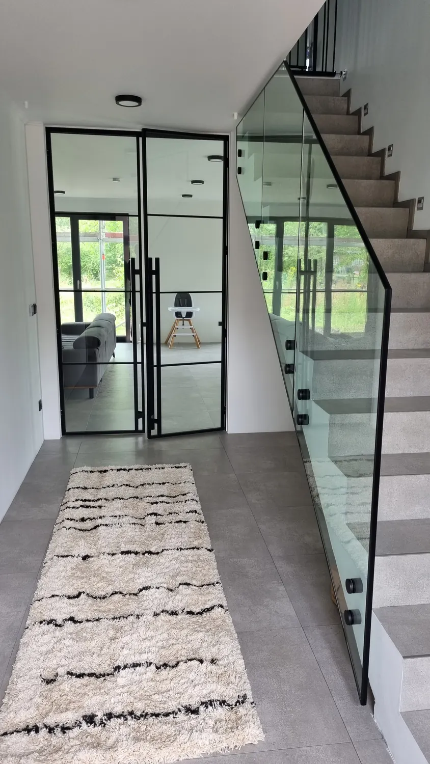 Lofttür neben einer Treppe mit Ganzglas-Geländer